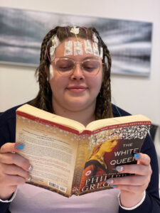 Lady wearing glasses and reading a book